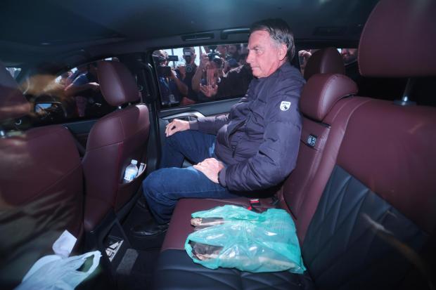 Brazil's former President Jair Bolsonaro leaves the Secretariat of Penitentiary Administration where he arrived after the Supreme Court ordered him to be fitted with an electronic ankle monitor in Brasilia, Brazil, Friday, July 18, 2025. (AP Photo/Luis Nova)