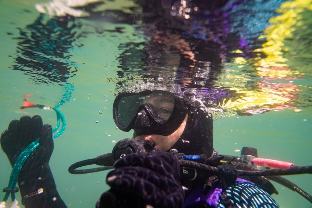 Hillary Glandon, an associate research scientist with Illinois Natural History Survey's Lake Michigan biologist station, surfaces after collecting sediment core samples on a dive at the artificial reef site, June 30, 2025, in Zion. (Audrey Richardson/Chicago Tribune)