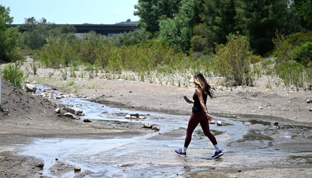 A woman walks across Trabuco Creek on a spring afternoon in O'Neill Regional Park in Trabuco Canyon on Tuesday, June 3, 2025. The park encompasses 4,500 acres in Trabuco and Live Oak Canyons and includes 23 miles of trails and a campground. (Photo by Mark Rightmire, Orange County Register/SCNG)