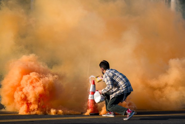 A man uses a traffic cone and baking soda to extinguish a tear gas bomb during protests against ICE outside the Federal Building in downtown in Santa Ana on Monday, June 9, 2025. (Photo by Leonard Ortiz, Orange County Register/SCNG)