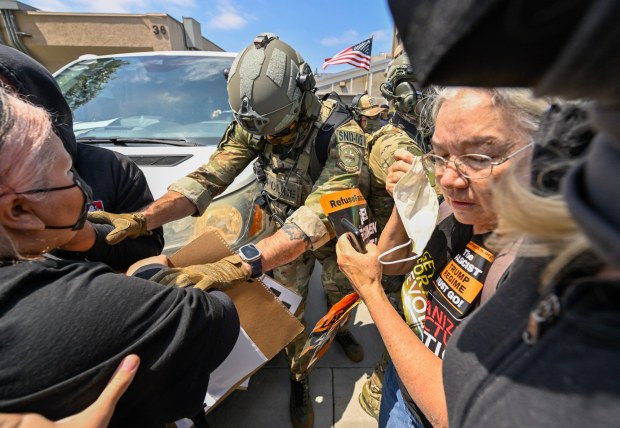 Police move protesters away from a van leaving the Federal Building in Santa Ana, CA, on Monday, June 9, 2025. About 200 anti-ICE protesters spent the afternoon carrying signs as they chanted and yelled at police. (Photo by Jeff Gritchen, Orange County Register/SCNG)