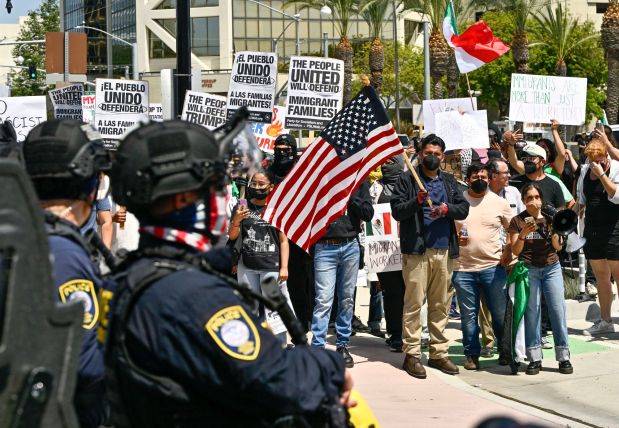Protesters yell at police at the driveway to the Federal Building while police stand guard in Santa Ana, CA, on Monday, June 9, 2025. About 200 anti-ICE protesters spent the afternoon carrying signs as they chanted and yelled at police. (Photo by Jeff Gritchen, Orange County Register/SCNG)