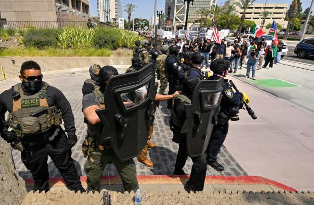 Protesters yell at police at the driveway to the Federal Building while police stand guard in Santa Ana, CA, on Monday, June 9, 2025. About 200 anti-ICE protesters spent the afternoon carrying signs as they chanted and yelled at police. (Photo by Jeff Gritchen, Orange County Register/SCNG)