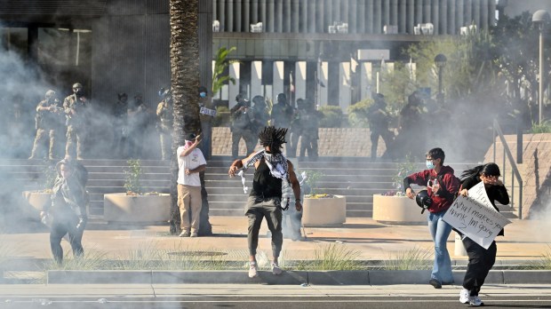Protester run from police as they use tear gas and flash-bangs at the Federal Building in Santa Ana, CA, on Monday, June 9, 2025. About 400 anti-ICE protesters spent the afternoon carrying signs as they chanted and yelled at police. (Photo by Jeff Gritchen, Orange County Register/SCNG)