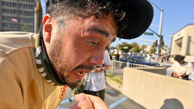 A protester washes his face after police used tear gas and flash-bangs at the Federal Building in Santa Ana, CA, on Monday, June 9, 2025. About 400 anti-ICE protesters spent the afternoon carrying signs as they chanted and yelled at police. (Photo by Jeff Gritchen, Orange County Register/SCNG)