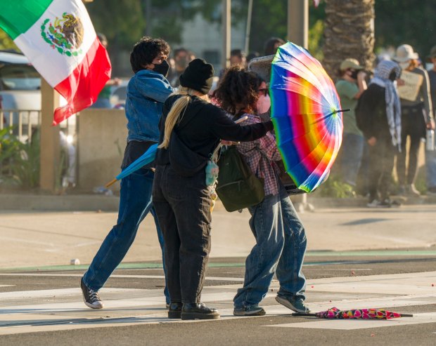 Protesters against ICE shield themselves against pepper balls with an umbrella outside the Federal Building in downtown in Santa Ana on Monday, June 9, 2025. (Photo by Leonard Ortiz, Orange County Register/SCNG)