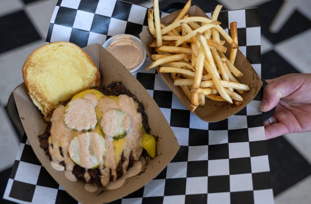 Jordan Smalls, owner of the new Smalls Smash Club in San Clemente, shows off a signature smash cheeseburger on Wednesday, July 16, 2025. (Photo by Mindy Schauer, Orange County Register/SCNG)
